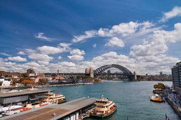 Fototapeta na wymiar SYDNEY - OCTOBER 2015: Panoramic view of Sydney Harbor on a sunny day. The city attracts 20 million people annually