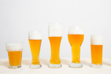Glasses filled with beer sorted by height 