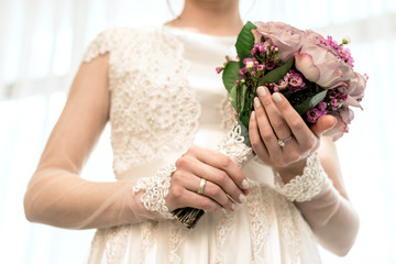 Obraz na płótnie Canvas hands of the bride with a beautiful wedding bouquet