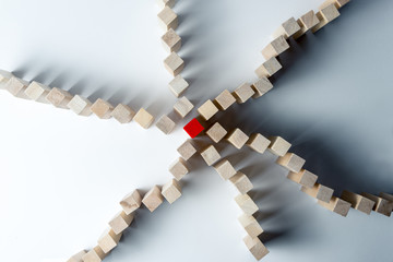 Many curved lines of wooden cubes are combined in the center into one red, as a symbol of queues, a...
