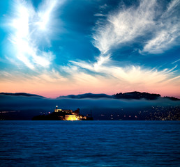 Naklejka na ściany i meble Alcatraz Island at sunset surrounded by the sea, San Francisco