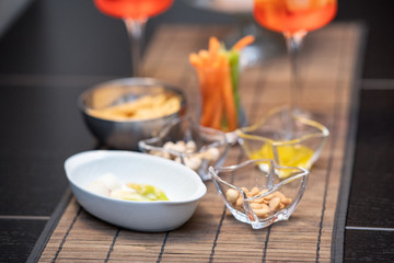 Closeup of nuts and glasses with cocktails with  straws