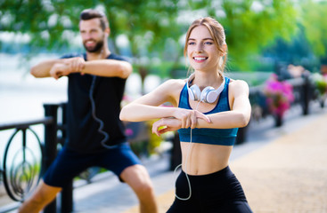 Happy couple doing exercises together, outdoors