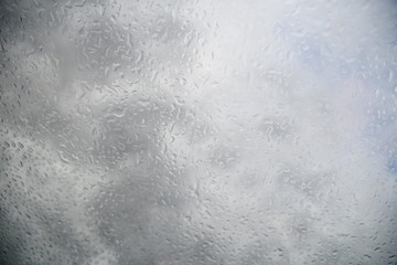 Obraz premium water drops on the glass against the background of clouds