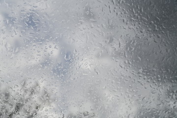 water drops on the glass against the background of clouds