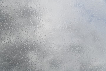 water drops on the glass against the background of clouds