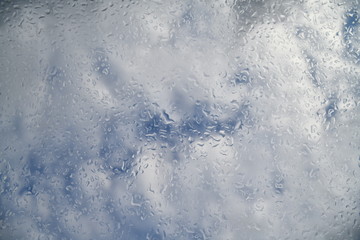 water drops on the glass against the background of clouds