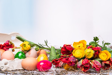Osterdeko mit bunten Ostereiern und Blumenstrauß