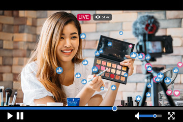 Young beautiful woman recording live stream video for makeup and cosmetics business purpose online...