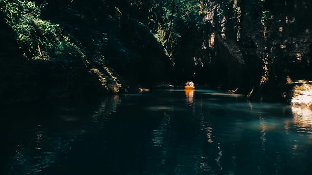 People Rafting In Rubber Rowing Boats in Natural Canyon. Beautiful River Among Cliffs