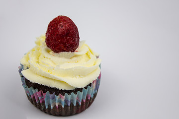 Chocolate-banana Muffins with cream and strawberries on a white background. Copy space