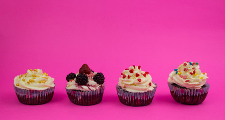 Various cream cupcakes on a pink background. The triumph of Copy space
