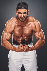 Obraz na płótnie Canvas Handsome Bodybuilder Flexing Muscles