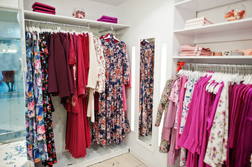 Female pink colorful clothing set of on the racks and shelves in clothing store brand new modern boutique. Spring summer dress collections.