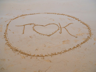 Love heart drawn in sand on beach