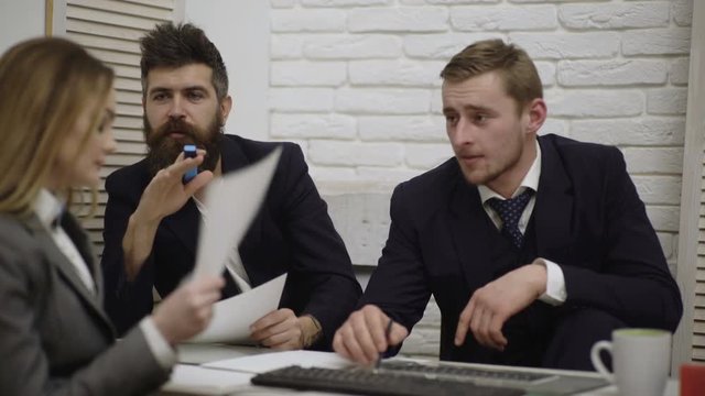 Happy young businessman and businesswoman team working together with laptop computer on desk discussing information in office. Boss and secretary discuss at white background.