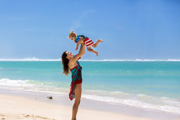 Happy beautiful fashion family, mom and children, dressed in hawaiian shirts, playing together on...