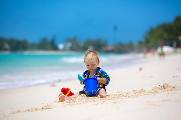 Happy beautiful fashion family, mom and children, dressed in hawaiian shirts, playing together on the beach