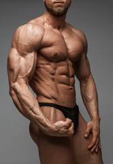 Fototapeta na wymiar Bodybuilder man with perfect abs, shoulders,biceps, triceps and chest.