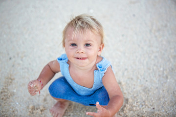 Happy beautiful fashion family, children, dressed in hawaiian shirts, playing together on the beach on sunset