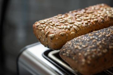 Brötchen mit Sonnenblumenkernen werden auf einem Toaster erhitzt