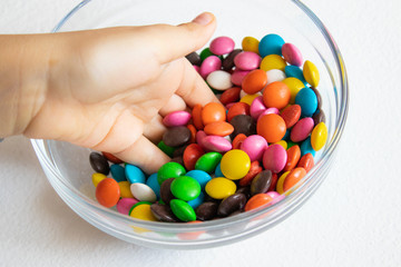 Round, multi-colored candies. Candy close-up, in a glass container.