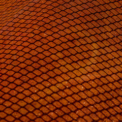 Shedow of weaved wire net on rusty metal sheet. Surface with depth of field, abstract industrial mesh background