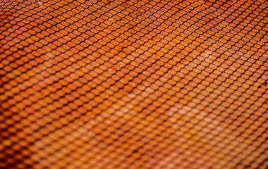 Shedow of weaved wire net on rusty metal sheet. Surface with depth of field. Horizontal industrial mesh background