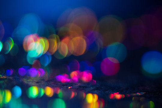 Distant blurred spots. Night city lights background. Faded lens flare colorful backdrop.