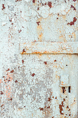 Texture of old rusty metal with keyhole, painted white which became orange from rust in some places. Horizontal texture of cracked white paint
