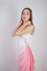 Fototapeta premium cute young teen girl stands in summer dress with pink Ombre on white background in Studio. 