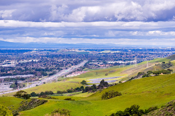 View towards San Jose and the bayshore freeway; green hills in the foreground; south San Jose, San Francisco bay area, California