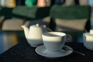 white cup with kettle on cafe table