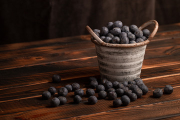 Heidelbeere im Eimer auf braunem hintergrund