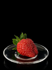 Strawberry on glass saucer