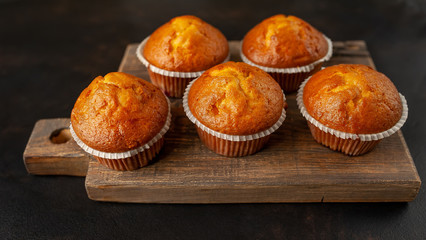 muffins with filling on a cutting board, against the background of dark concrete