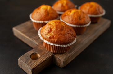 muffins with filling on a cutting board, against the background of dark concrete