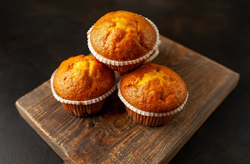 muffins with filling on a cutting board, against the background of dark concrete