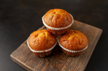 muffins with filling on a cutting board, against the background of dark concrete