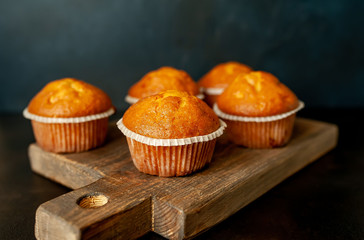 muffins with filling on a cutting board, against the background of dark concrete