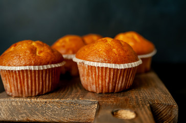 muffins with filling on a cutting board, against the background of dark concrete