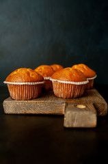 muffins with filling on a cutting board, against the background of dark concrete