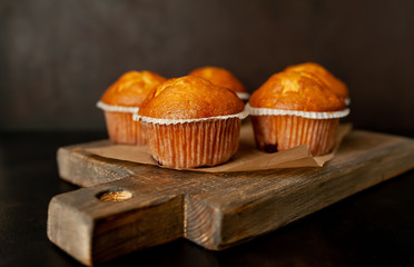 muffins with filling on a cutting board, against the background of dark concrete