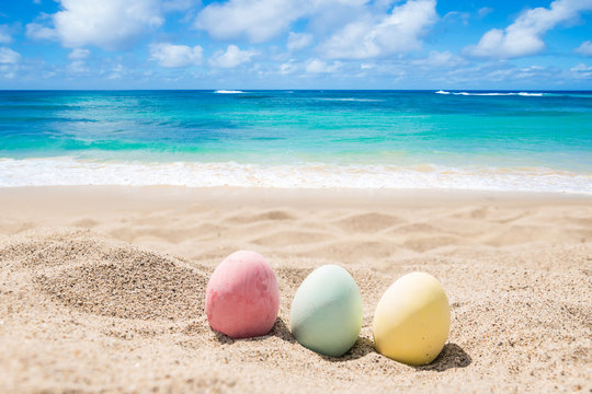 Happy easter lettering background with eggs on the sandy beach