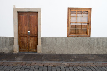 Typical Canarian house fronts / facades with plastered or tiled walls, barred windows and shutters found alongside the coast of this sunny island. 