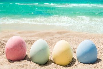 Happy easter lettering background with eggs on the sandy beach
