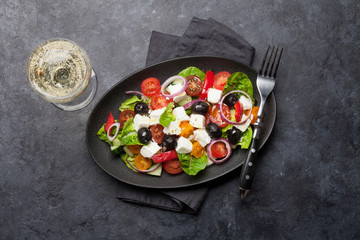 Greek salad plate and white wine