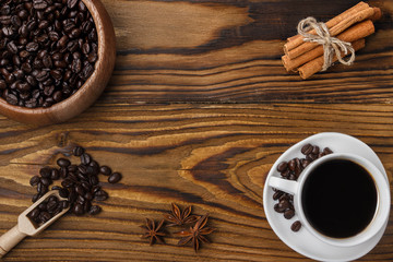 Obraz na płótnie Canvas Freshly hot brewed coffee. Coffee beans, cinnamon and anise stars on a dark wooden background