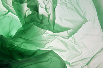 Plastic bag concept. Polyethylene may use as background. Plastic of different shades of green. Background for design. Template for card, poster, banner design. Colourful texture.