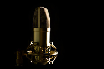 Studio microphone isolated on black background with side lightning